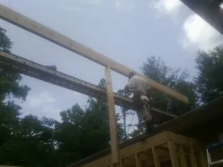 Carpenter setting a ridge beam over a new addition frame — Ice Dam Removal by Roofing Brothers in Seguin
