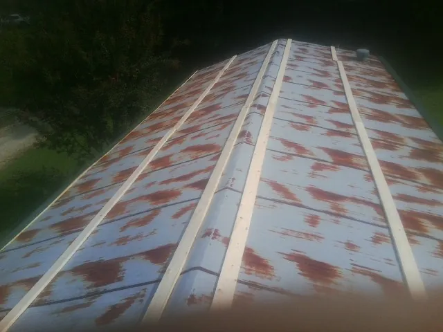 Rusted metal roof panels with new wood purlins before replacement — Storm Damage Roof Repair in Seguin by Roofing Brothers