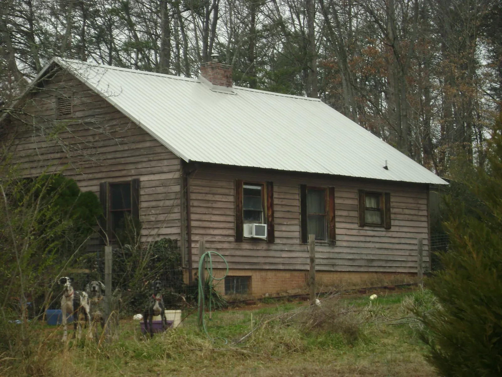 White metal roof on an old wood sided farmhouse, from a Metal Roof Installation job in Seguin